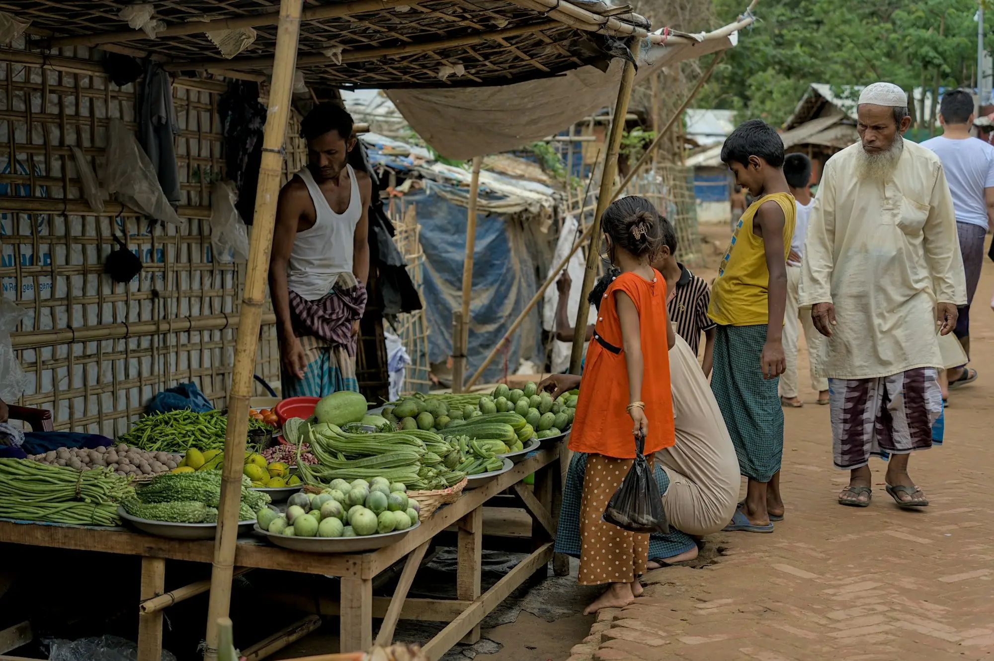 Customers browsing fresh produce at an outdoor market stall