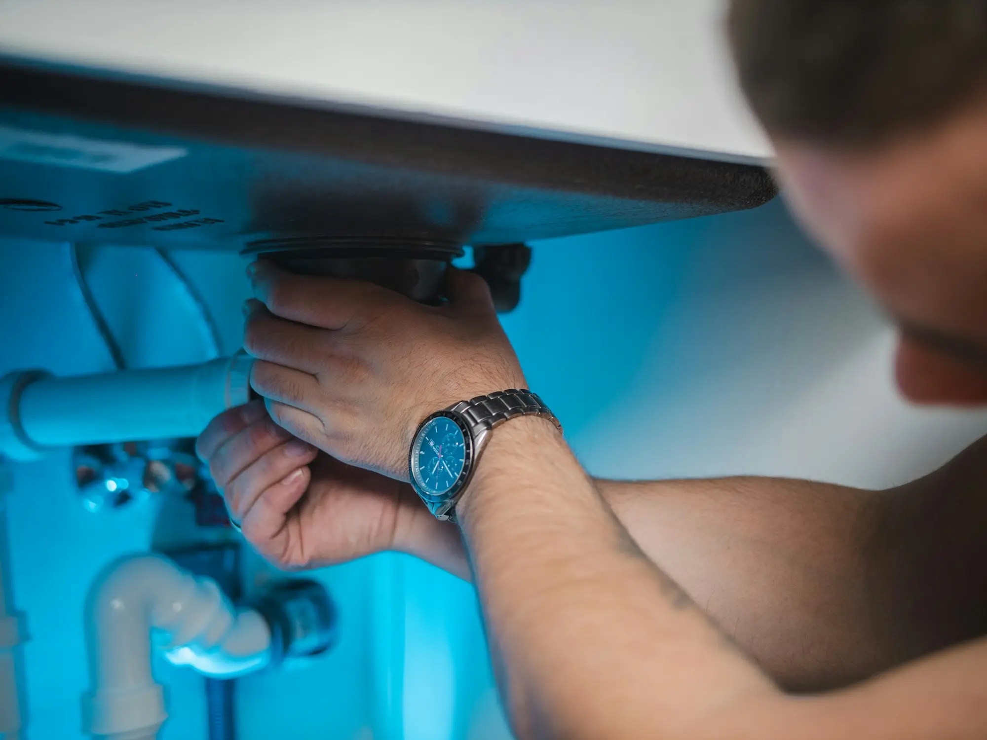 Tradesperson repairing a hot water system inside a building